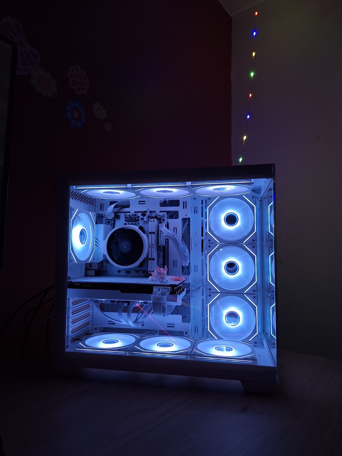 Dezelfde witte pc van voren, met lichtjes aan de muur ernaast