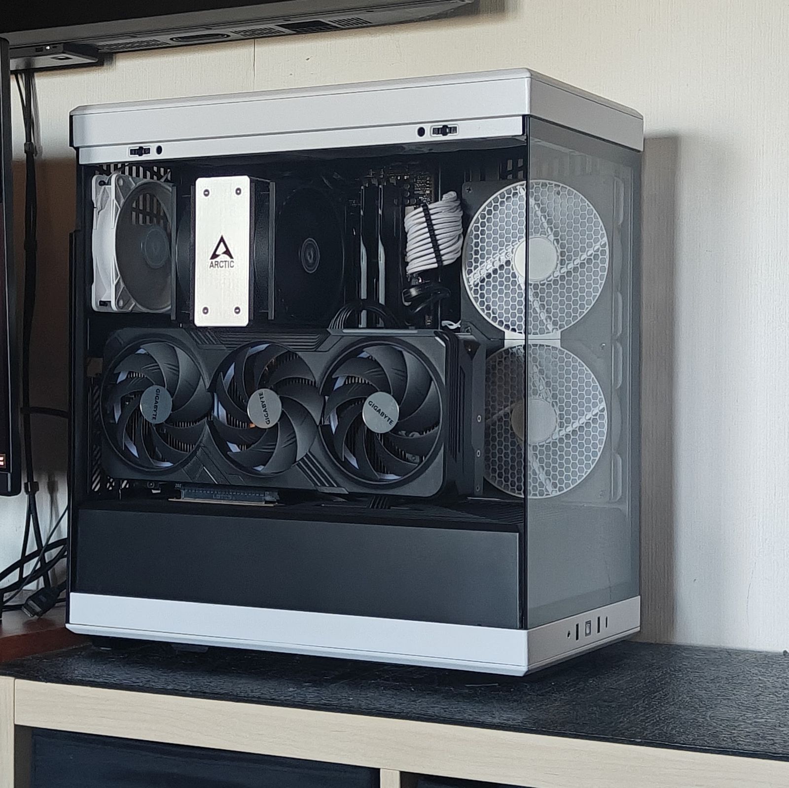 Pc in een wit-zwarte kast met een Gigabyte-videokaart met drie fans, in daglicht